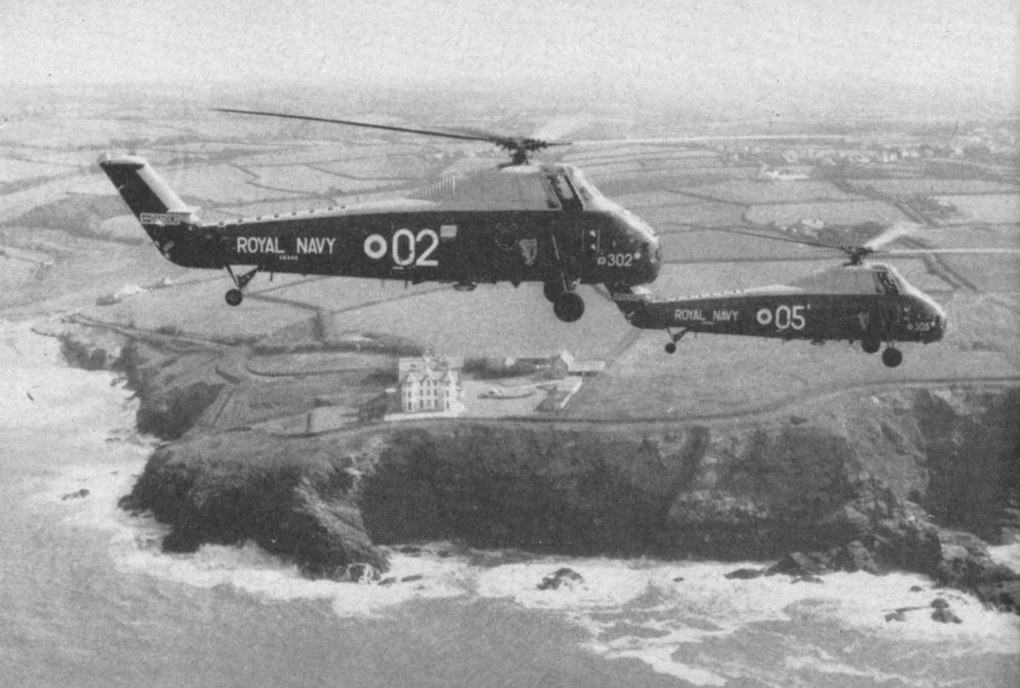 Wessexes “302” and “305”, piloted by Lieut. D. G. H. Fraser, R. C. N. and Sub. Lieut. N. P. E. Edwards respectively, pass Poldhu on the Cornish coast.