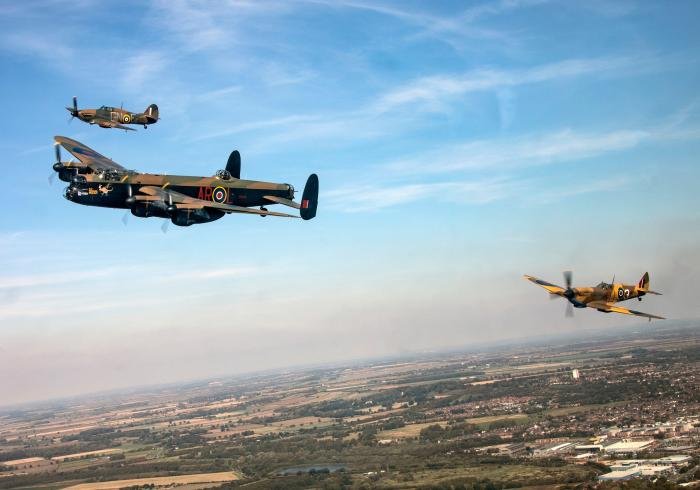 Pictured are three aircraft from the Battle of Britain Memorial Flight (BBMF) in the skies above Lincolnshire. Top left is Hurricane LF363, painted to represent 249 Squadron Battle of Britain Hurricane ‘GN-F’ on its port side. GN-F was the aircraft flown during the Battle of Britain by fighter ace Wing Commander Tom Neil DFC and Bar AFC AE LdH. 'SD-A' code letters on LF363's starboard side are the code letters of the 501 Squadron Hurricane flown by Paul Farnes DFM also during the Battle of Britain. Centre left is Lancaster PA474 wearing 460 Squadron (RAAF)'s AR-L on her portside and 50 Squadron VN-T on her starboard side. Right is a Spitfire MK356. 'MK' has been painted in a desert camouflage to represent Spitfire Mk IX EN 152/QJ-3 of 92 Squadron based in Tunisia during 1943.