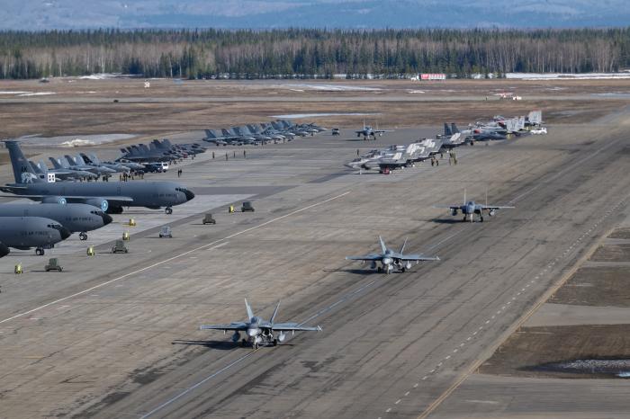 Typical scene at Red Flag-Alaska at Eielson AFB – Two F-15C Eagles from 67th FS taxi behind two RCAF CF-18A Hornets. Clockwise in the image from top left are KC-135Rs from the 168th AR,  E/A-18G Growlers of VAQ-209, F-35B Lightning IIs of VMFA-122, CF-18A Hornets of 401 Sqn RCAF, F-15C Eagles of 67th FS, and F-35B of VMFA-242.