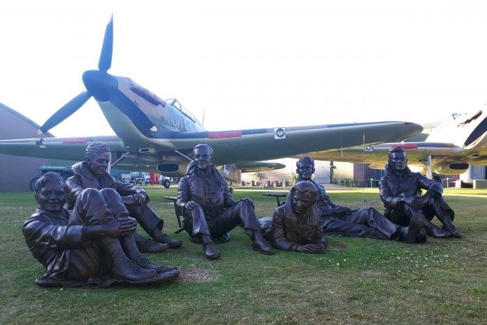 The bronze statues of seven No 32 Squadron pilots in front of one of Hawkinge’s three Hurricane replicas.