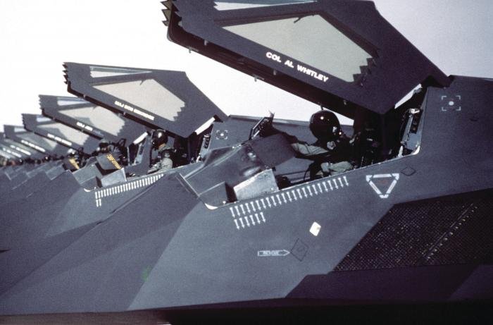 A row of F-117 with canopies raised following their return from Saudi Arabia where they took part in Operation Desert Storm. Mission marks are visible below the cockpits.