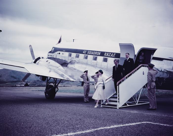 Queen Elizabeth II and Prince Philip, the Duke of Edinburgh, are pictured leaving a 42 Squadron RNZAF Douglas Dakota at Westport Airport during her Commonwealth visit to New Zealand in January 1954.