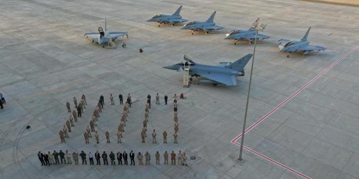 A mixture of Leonardo and Kuwait Air Force personnel pose in front of the fleet of Eurofighter Typhoons which surpassed 100 hours of flying.  