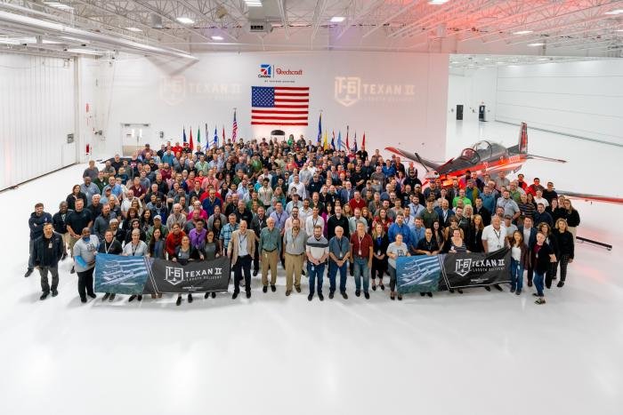 Staff of Textron Aviation Defense proudly stand infront of the companies 1000th Texan II which has been delivered to the Columbian Air Force