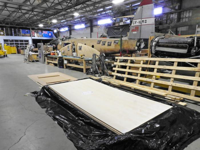 Not just any old pile of wood from the building supplies yard, but the prized British Standard 6V3 grade of plywood after arrival in the restoration hangar at Nanton. The tail of Mosquito B35 CF-HMS wears the markings it bore while flying with Spartan Air Services during the 1950s and early ’60s.