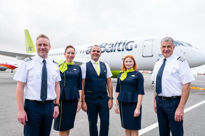 The airBaltic crew standing in front of their aircraft on the ground in Luanda.