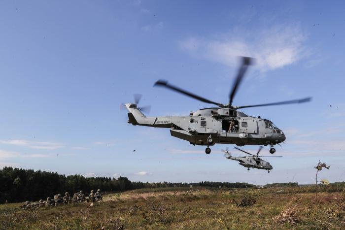 Two Royal Navy Merlin HC.4 helicopters drop off troops during a training exercise