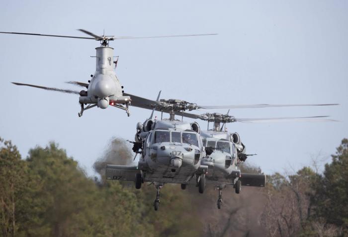 Two MH-60S Knighthawks and an MQ-8B Fire Scout from the US Navy's HSC-22 'Sea Knights' conduct hover checks before departing the Mid-Atlantic Regional Spaceport's Unmanned Aircraft Systems (MARS UAS) Airfield - located at NASA Goddard's Wallops Flight Facility in Virginia - for an Airborne Use of Force training flight on February 24, 2020.