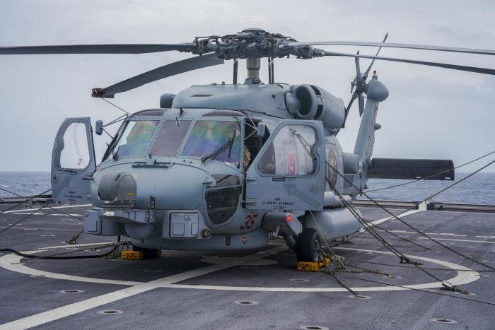 US Navy pilots conduct pre-flight checks in the cockpit of an MH-60R assigned to Helicopter Maritime Strike Squadron 35 (HSM-35) 'Magicians' aboard the littoral combat ship, USS Oakland (LCS-24), before departing on a mission over the Natuna Sea on February 28, 2023.