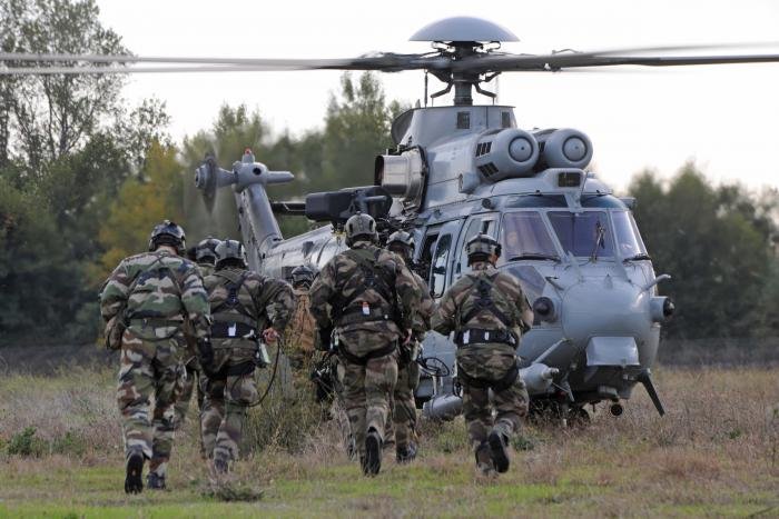 Troops rush to embark on an AS532U2 Cougar medium-lift tactical transport helicopter operated by the RNLAF's No 300 Squadron 'Wildcats' at an undisclosed location in the Netherlands.