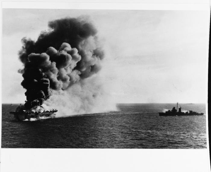Burning in the Sulu Sea, off Luzon, on 4 January 1945, after being hit by a kamikaze aircraft. A destroyer is standing by with fire hoses ready