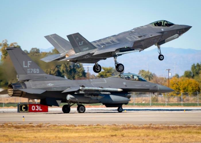 An F-35A Lightning II (serial 12-5045 'LF') from the USAF's 61st Fighter Squadron (FS) 'Top Dogs' lands at Luke AFB, Arizona, while an F-16CM Fighting Falcon (serial 90-0769 'LF') assigned to the 310th FS 'Top Hats' prepares to depart December 15, 2020.
