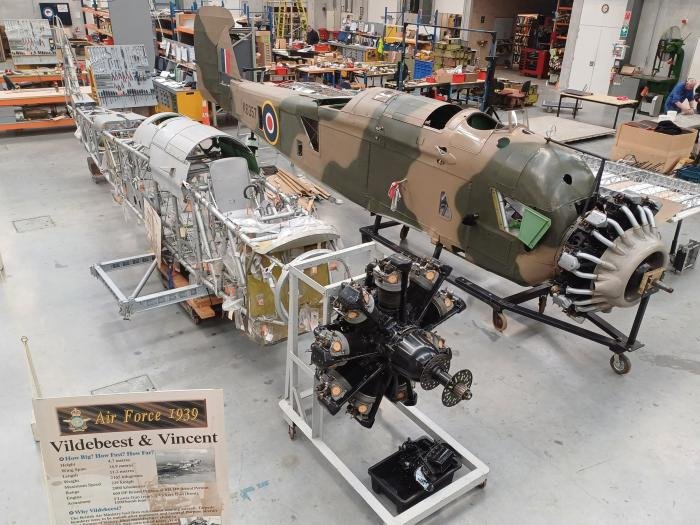 The Air Force Museum of New Zealand’s Vickers Vildebeest project, NZ102, in the foreground, with the newly arrived, camouflaged Subritzky family Vincent, K6357/NZ311, behind it in the restoration hangar at Wigram.