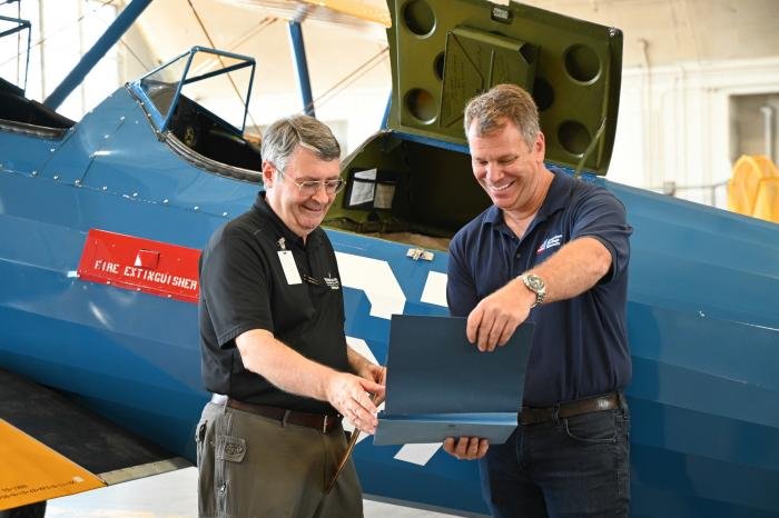 David Tillotson III (left), director of the National Museum of the USAF, examines documentation on the PT-17 with Collings Foundation executive director Rob Collings.