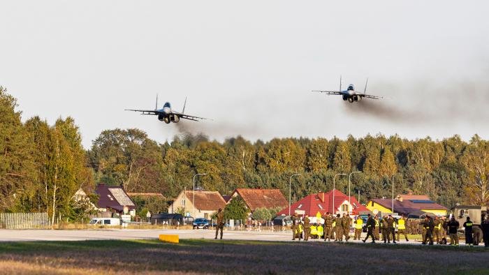 A pair of MiG-29s low, fast and smoky, travelling down route 604 with Przezdziek Wielki in the background.