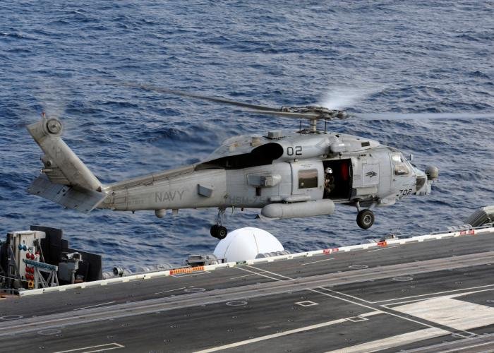 A US Navy MH-60R Seahawk assigned to Helicopter Maritime Strike Squadron 75 (HSM-75) 'Wolfpack' gets airborne from the flight deck of the aircraft carrier, USS Nimitz (CVN-68), on December 1, 2016.