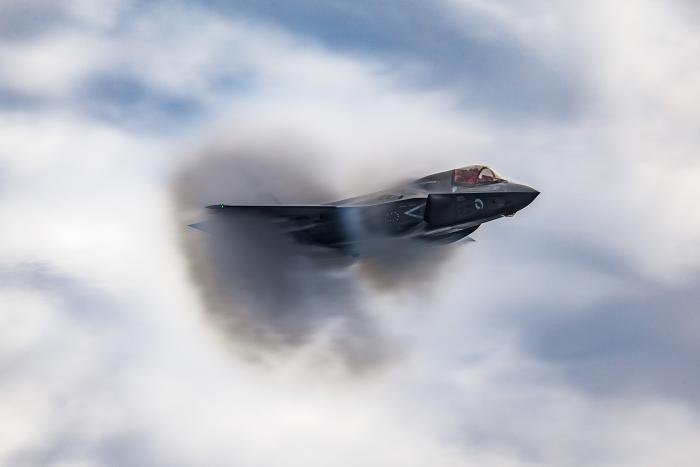 An F-35B Lightning creating a vapor cone as it flies past HMS Queen Elizabeth. 
RAF Photographic Competition 2023 Winner:
Category D: Peoples Choice Judges Nominations
Award: 10
Image title: Vapor Cone
Photographer: AS1 Natalie Adams